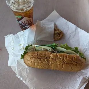 Tuna sandwich on a fresh baguette, with chocolate chip cookie and iced tea