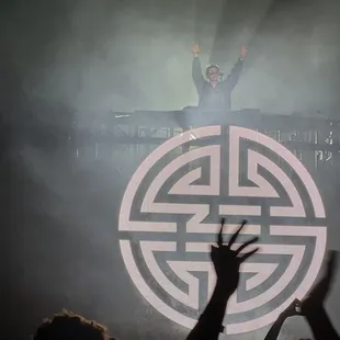 a man on a stage with his arms in the air