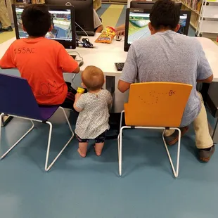 Nearly-one-year-old daughter trying to make friends with Big Kids at the children's computer lab.