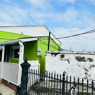 a green building with a white fence
