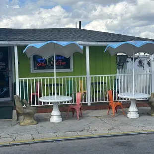 a green building with a white fence