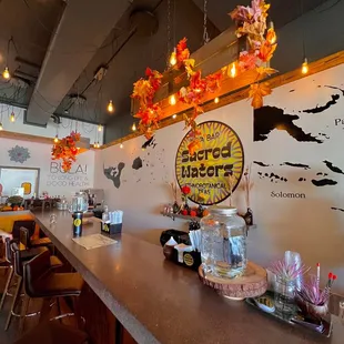 a restaurant with a long bar with a sign on the wall