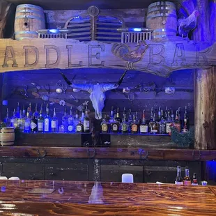 a wooden bar with a sign that says saddle