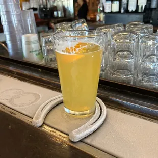 a glass of beer on a coaster