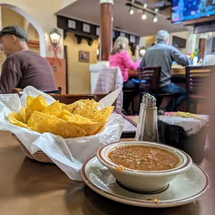 a basket of chips and a bowl of salsa