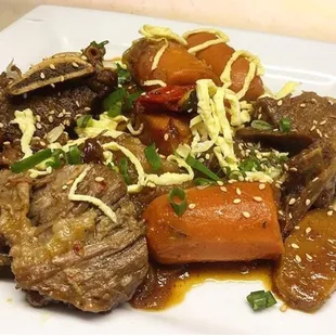 Steamed Kalbi (Kalbi Jim) - steamed big bone short-rib in our special kalbi jim sauce along with peppers, daikon, and carrots