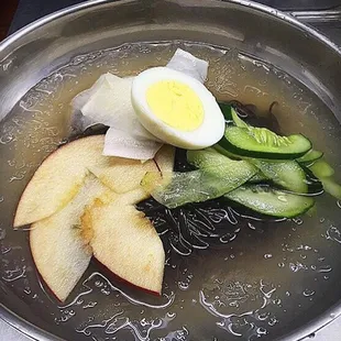 Naeng Myun - Cold buckwheat noodles in ice cold broth served with pickled cucumber and daikon, sliced apples and half a boiled egg