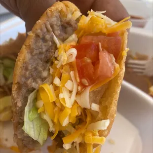 a hand holding a taco