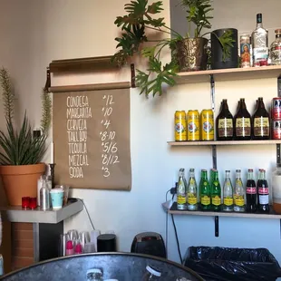 a table with bottles of wine and a menu on the wall
