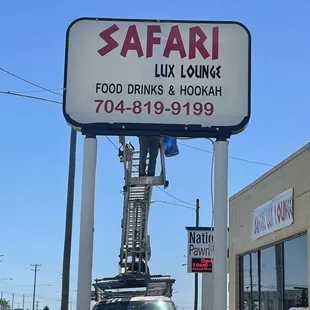 a man on a ladder working on a sign