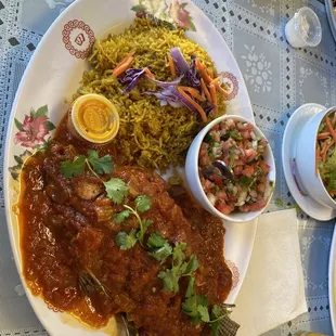 Wet fry tilapia with pilau and tomato, onion, pepper salad