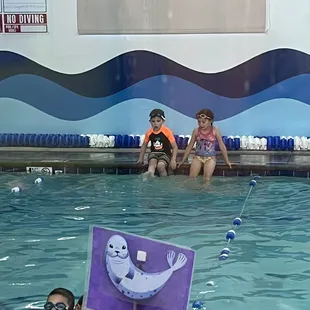 My kids left on the side of a pool, instructor busy across the pool with her back turned.