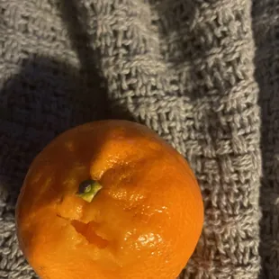 an orange on a knitted blanket