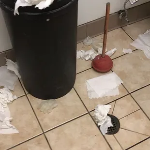 Overflowing trash in a disgusting restroom