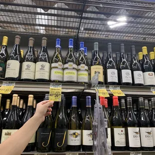 a hand reaching for a bottle of wine