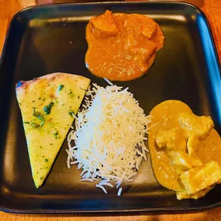 Plate with fish curry curry chicken, rice, and Frankie Naan