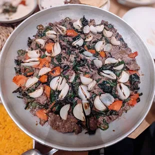 Southeast dish kebab. Lamb and beef, pearl onions, tomato, beet greens, ginger, Serrano, yogurt, and served with turmeric rice.