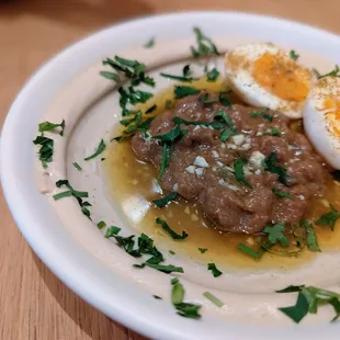 Hummus ful. Slow cook fava beans. Cumin, lemon pickled Fresno&apos;s, soft egg, with challah bread