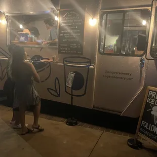 a woman standing in front of a food truck