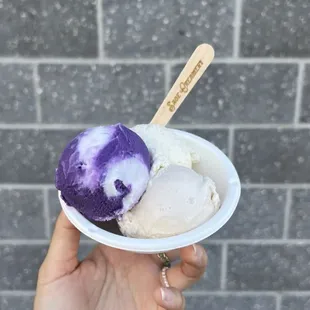 a hand holding a bowl of ice cream