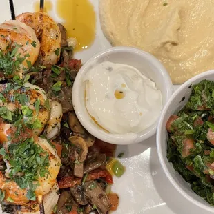 a white plate with shrimp, mushrooms, and a side of mashed potatoes