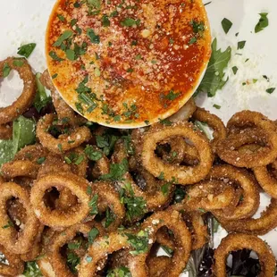 a plate of onion rings and a dip