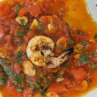 a plate of food with shrimp and tomatoes