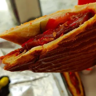 Basturma sandwich - Thinly shaved air-dried cured seasoned beef slices with pickles and tomatoes in a panini pressed like crispy bread.