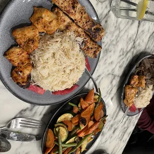  a plate of chicken, rice, and vegetables