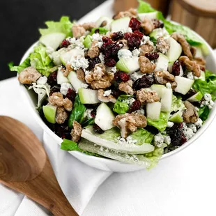 a bowl of salad with walnuts and cranberries