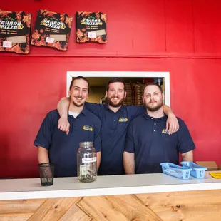 two men standing behind a counter