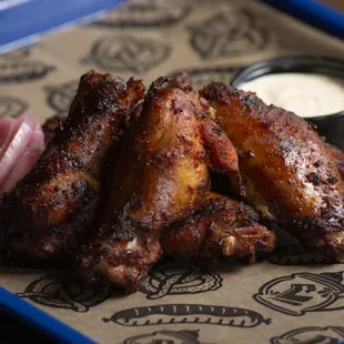 a tray of chicken wings with dipping sauce