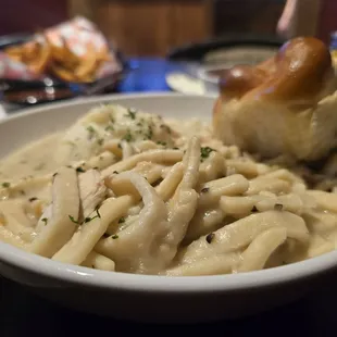 Chicken noodles with mashed potatoes and a roll