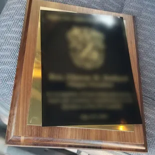 Plaque with top right corner bent from impacting the floor when it fell off.