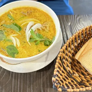 a bowl of soup and a baguet