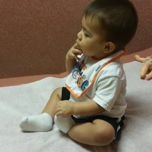 Ezekiel trying to bite his bandaid off. It's not coming off! Good job nurse!!