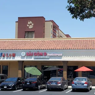 the outside of a restaurant with cars parked in front of it