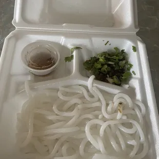 a tray of noodles and a bowl of sauce