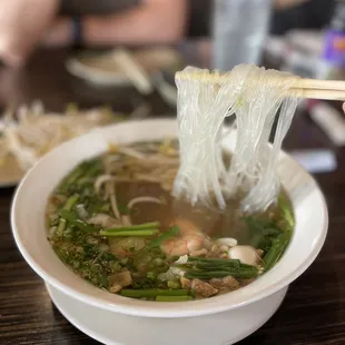 a bowl of soup with chopsticks