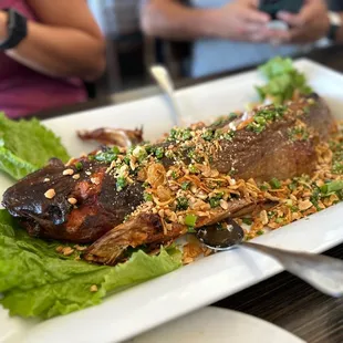 a plate of fish with lettuce