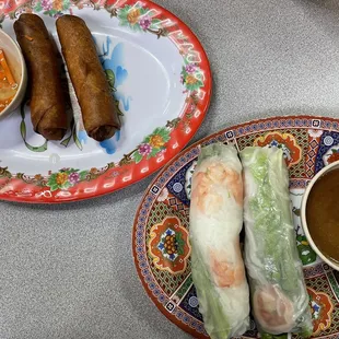 a plate of spring rolls and a bowl of dipping sauce