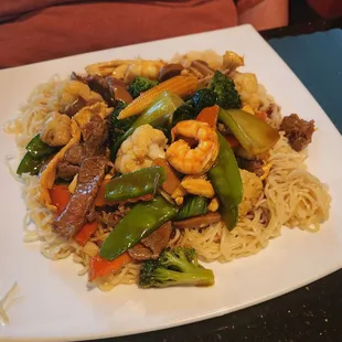 Chicken, shrimp, beef, and vegetables stir-fried in a brown garlic sauce served over noodles