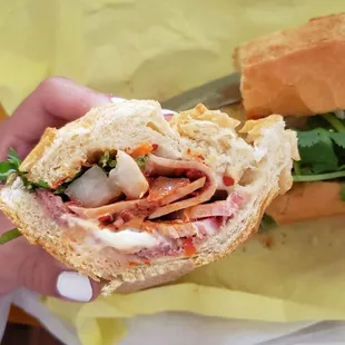 a person holding a sandwich