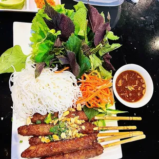a plate of noodles, meat, and vegetables