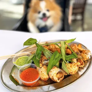 Ồc Nhảy Nương Bơ Tởi: Grilled Escargot in Butter Garlic w/ fresh rau ram, ginger fish sauce | $18.95