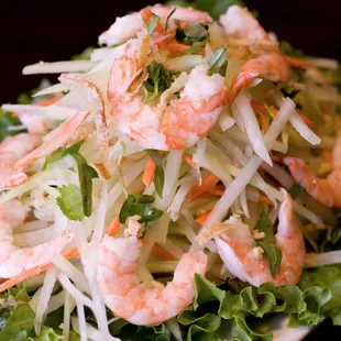 a plate of salad with shrimp and lettuce