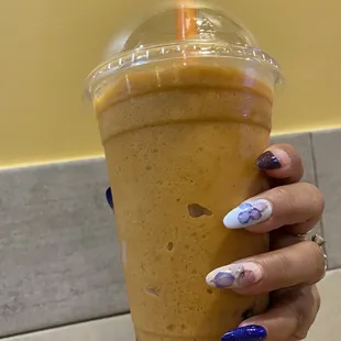 a hand holding a cup of iced coffee