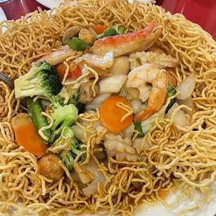 a plate of noodles with shrimp, broccoli and carrots