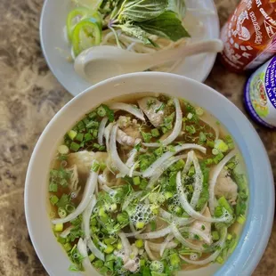 a bowl of soup and a bottle of soda