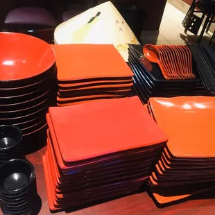 a stack of orange plates and bowls
